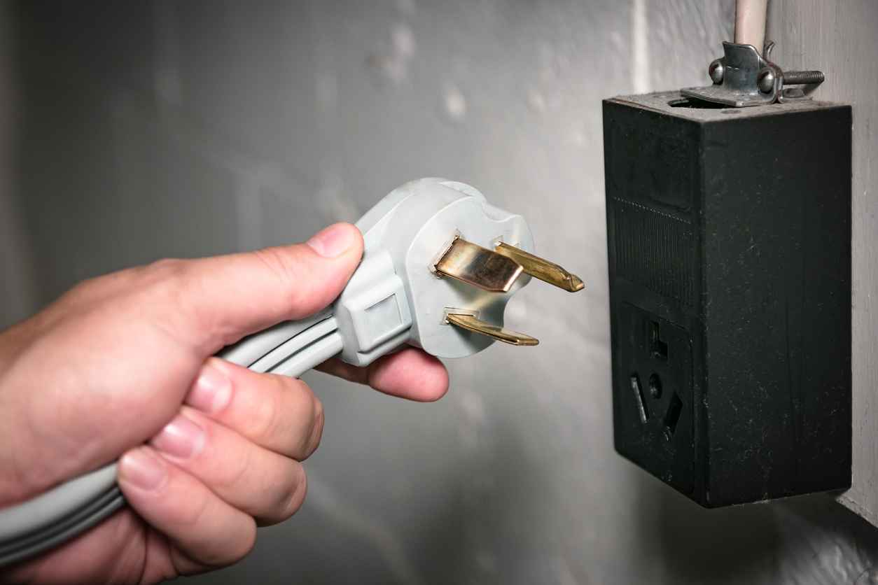  Closeup view of 3 prong electric dryer cord and 240 volt socket. 